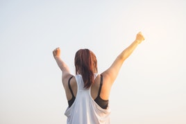woman wins with both arms up